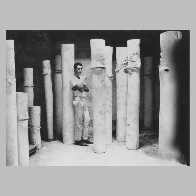 Iginio Balderi ritratto in studio nel 1961 con le sculture in gesso della serie Colonne